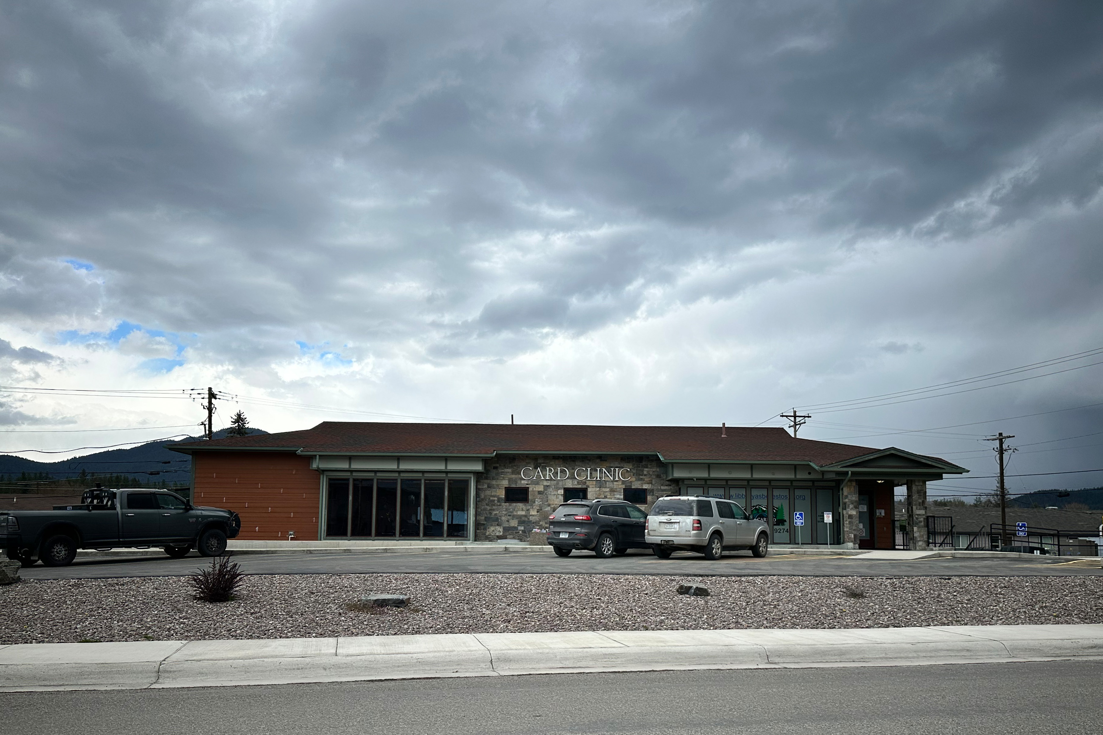 A one-story brick, brown roofed building that reads: "CARD CLINIC" in white letters