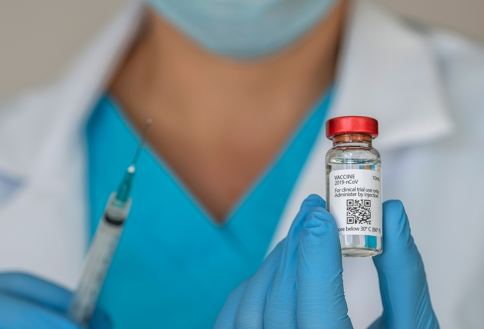 A photograph of a person holding a vaccine and a syringe