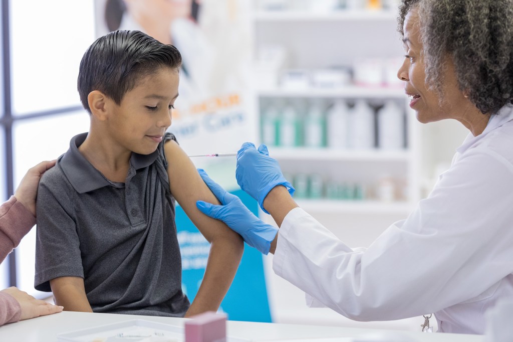 A photograph of a young boy getting a vaccination
