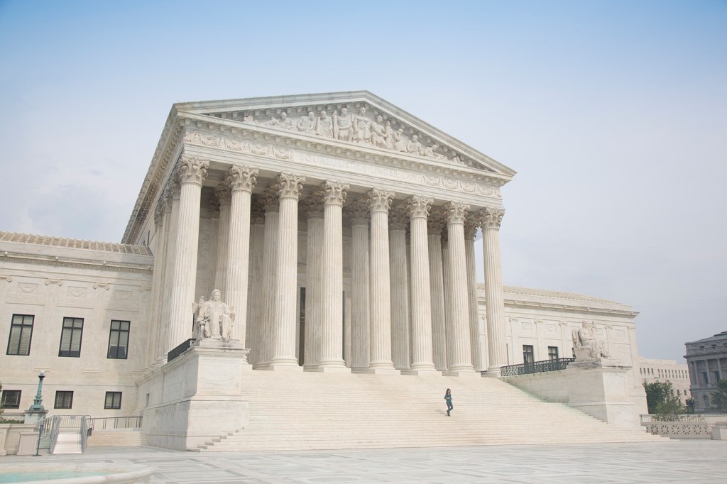 A person descends the steps of the United States Supreme Court Building.