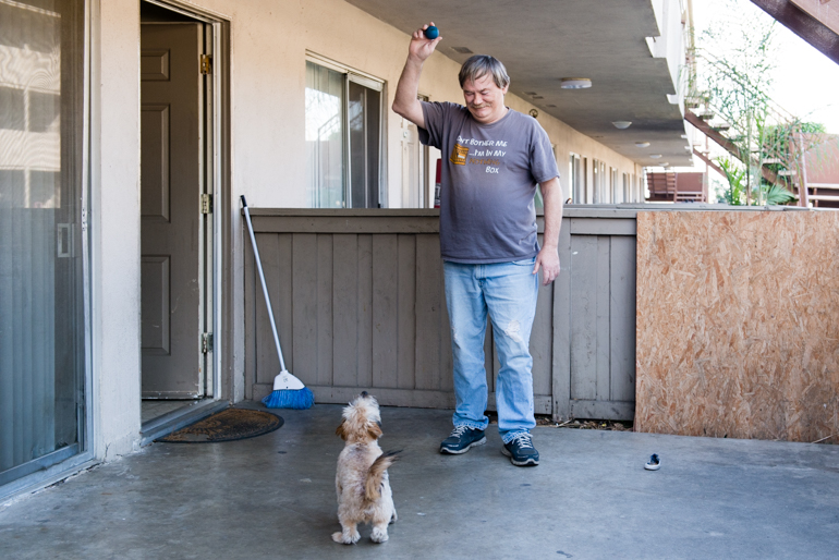 Meade plays with his puppy Scrappy in his apartment patio. “If I lost this apartment, I would give Scrappy to my neighbors…I wouldn’t want him to be stressed out living in the streets.”(Heidi de Marco/California Healthline)