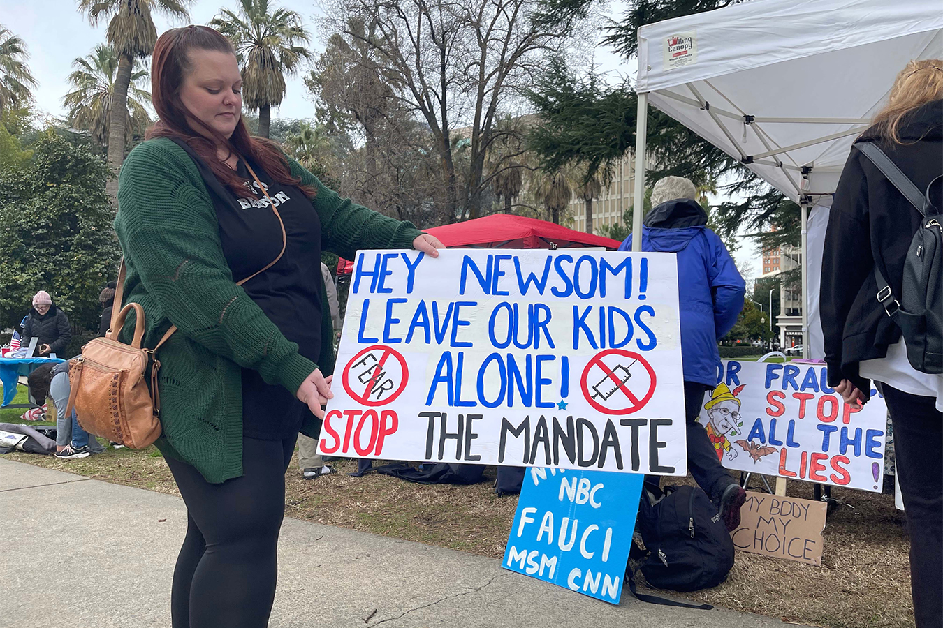 Jessica Holloway, a vaccine protester, holds a sign at an anti-vaccine rally at the California Capitol in early January.