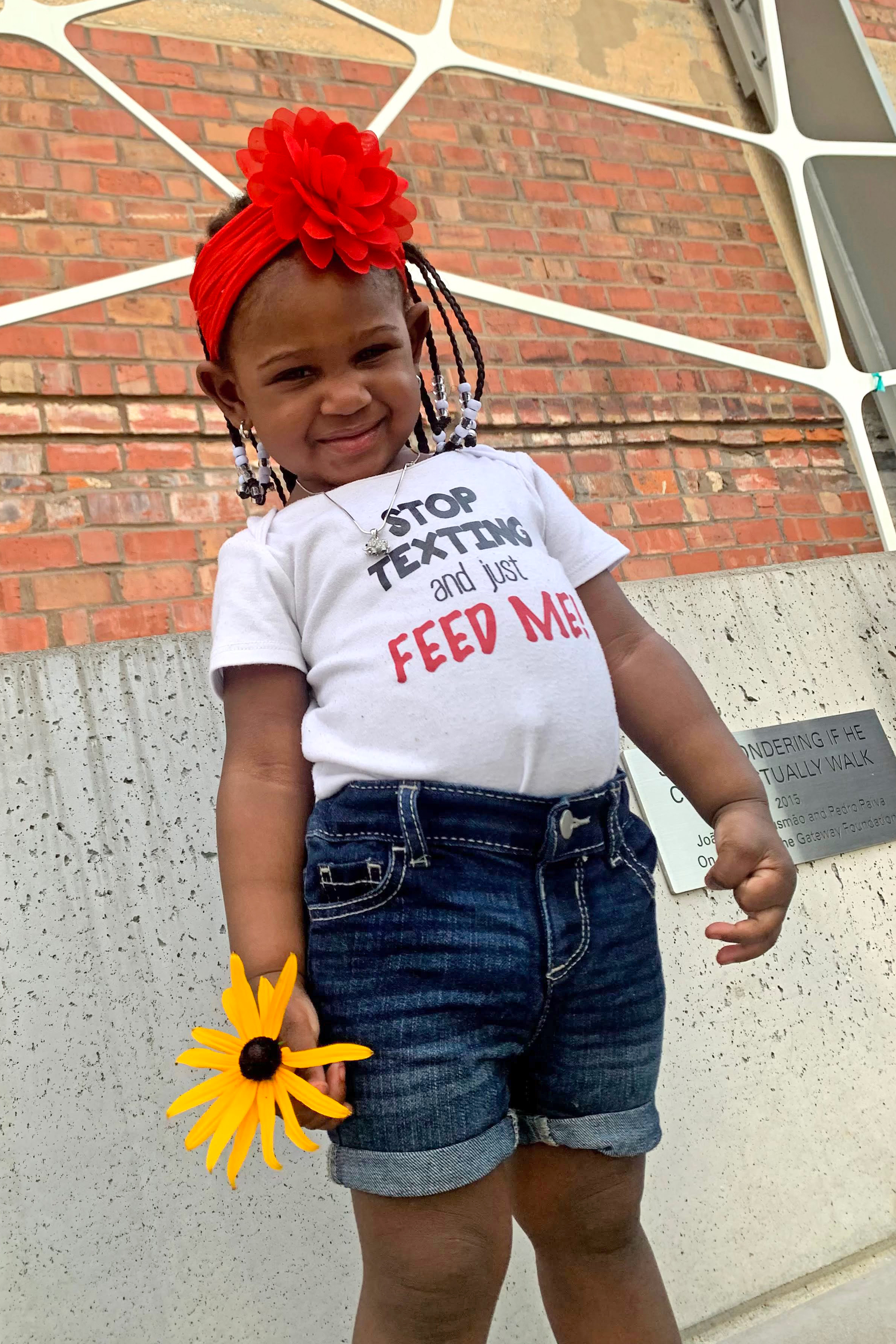 Calyia Stringer is seen in a family photo holding a yellow flower.