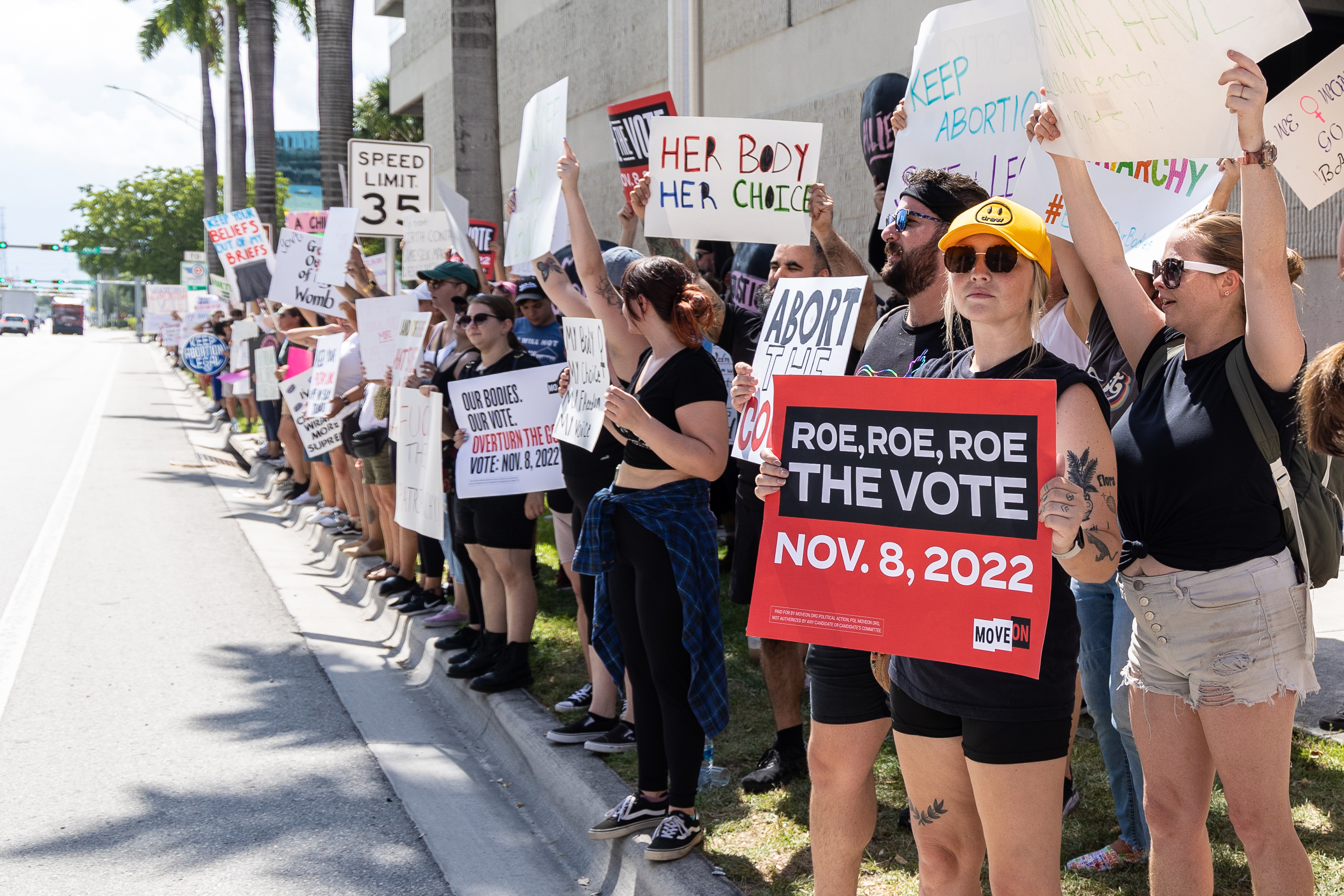 A photo shows activists holding signs on a sidewalk.
