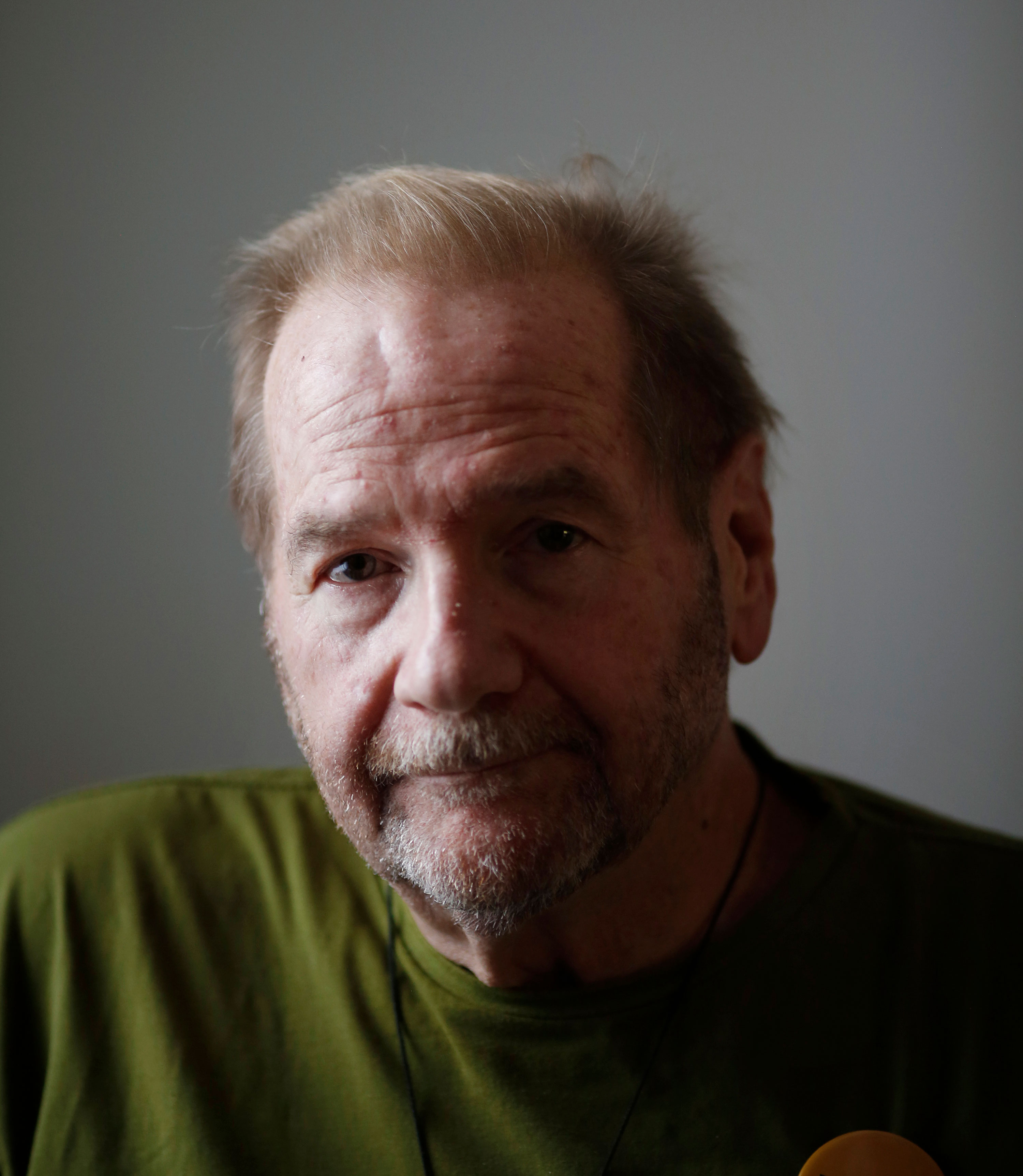 A photo shows Jerry Bilinski posing for a portrait by a window, casting the right side of his face in shadow.