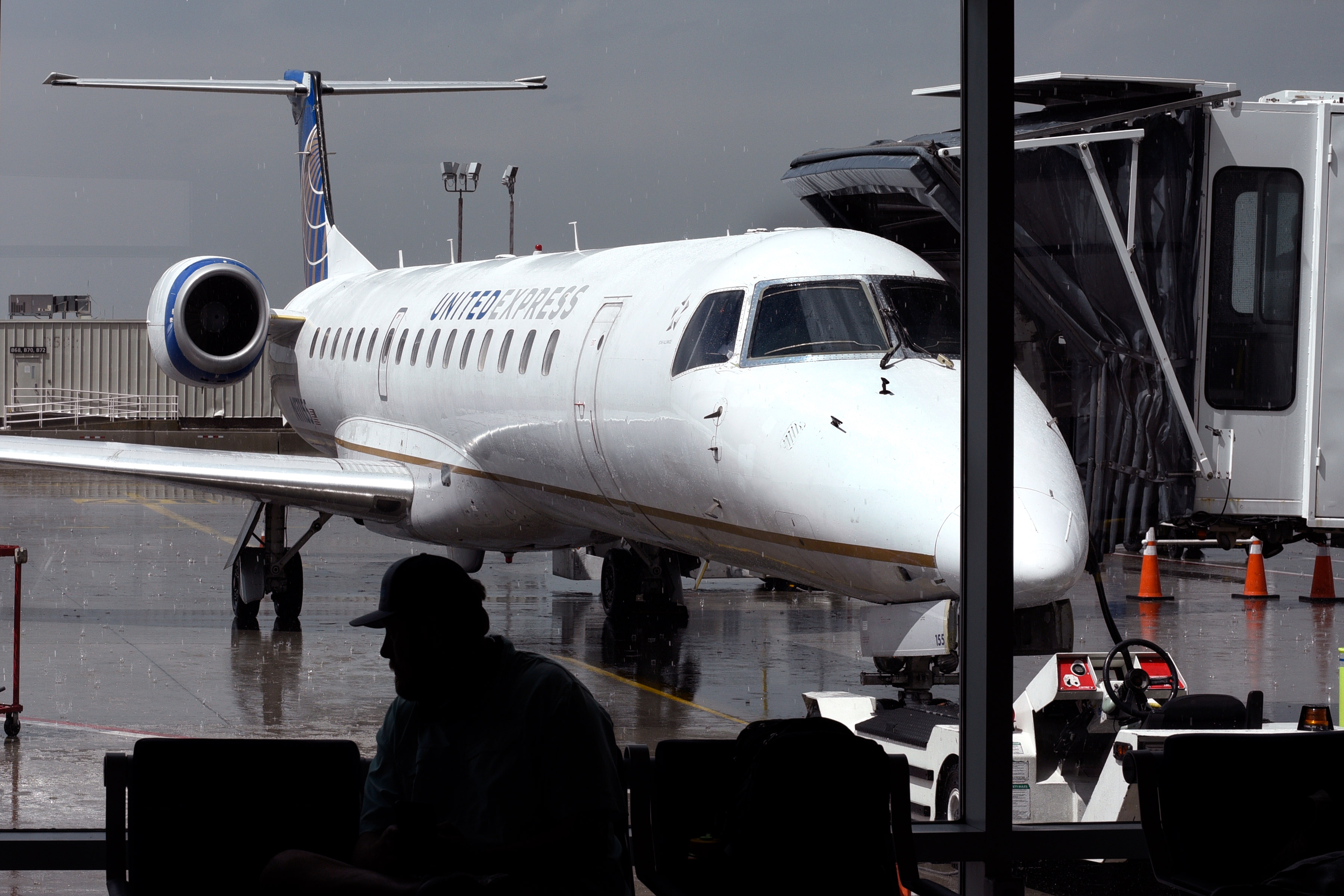 A photo of a commercial airplane seen from a window inside an airport.