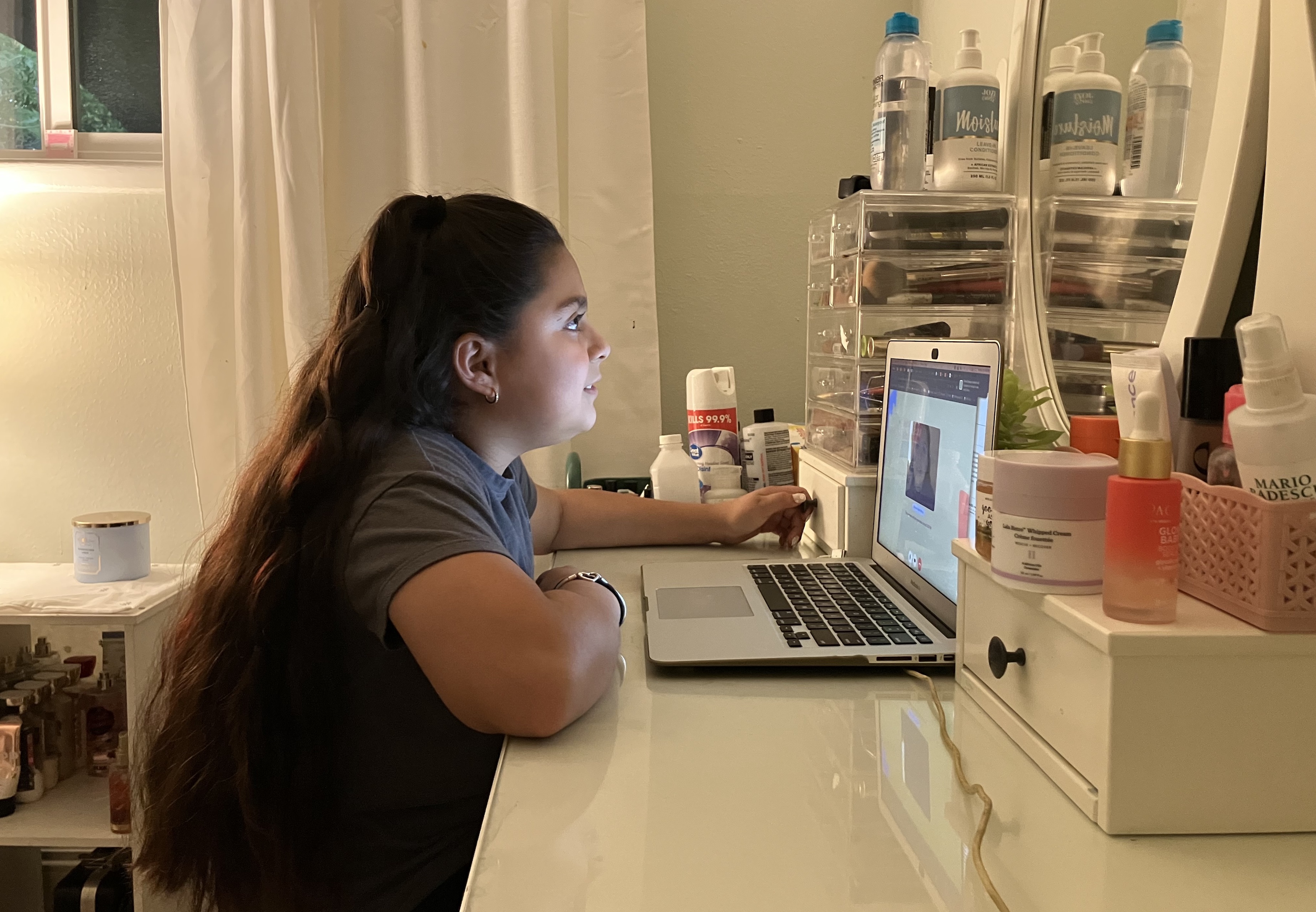 Anjelah Salazar, a fifth grade girl, sits at her desk in front of her computer.