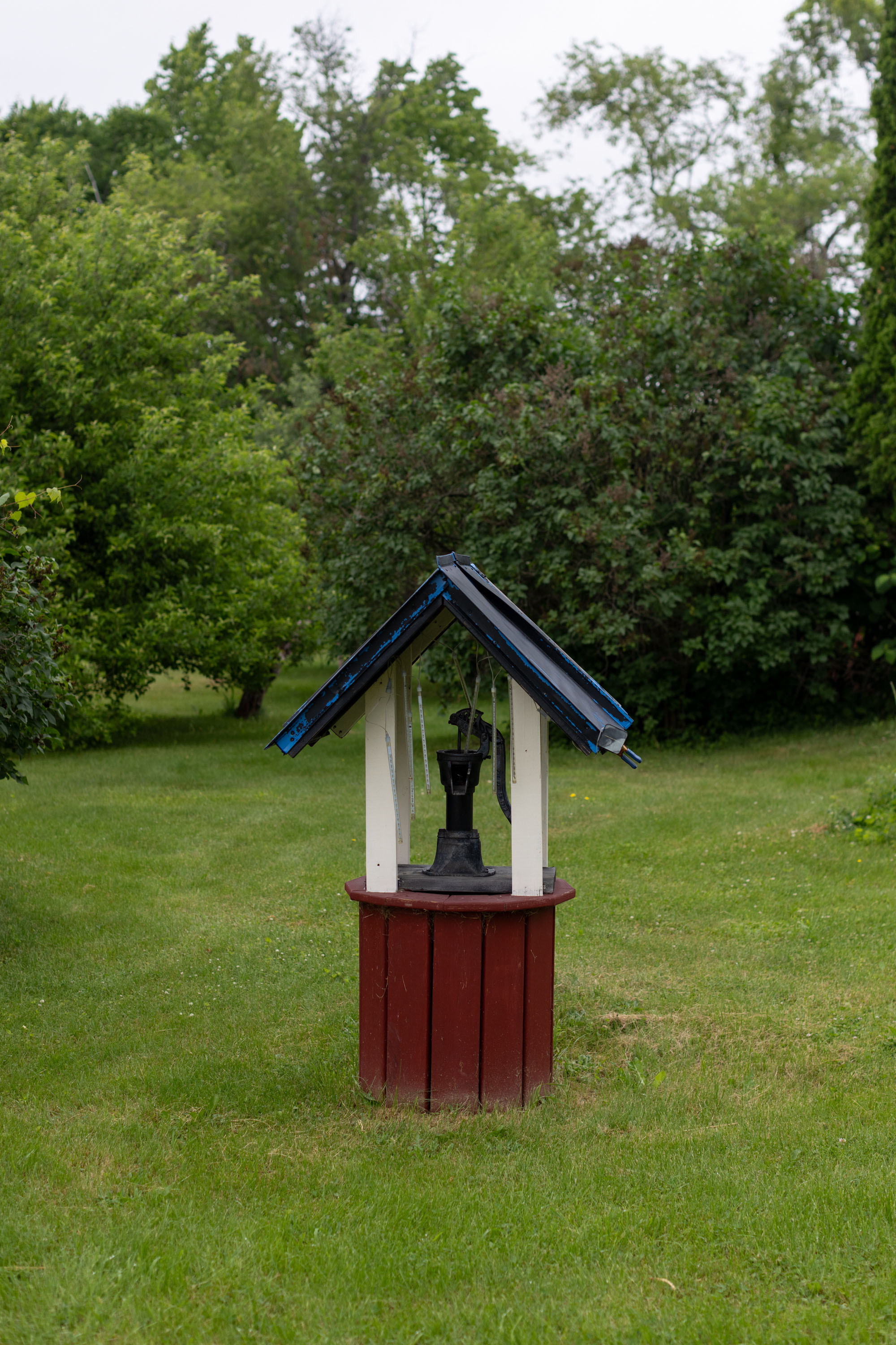A photo of a water well in a grassy area.