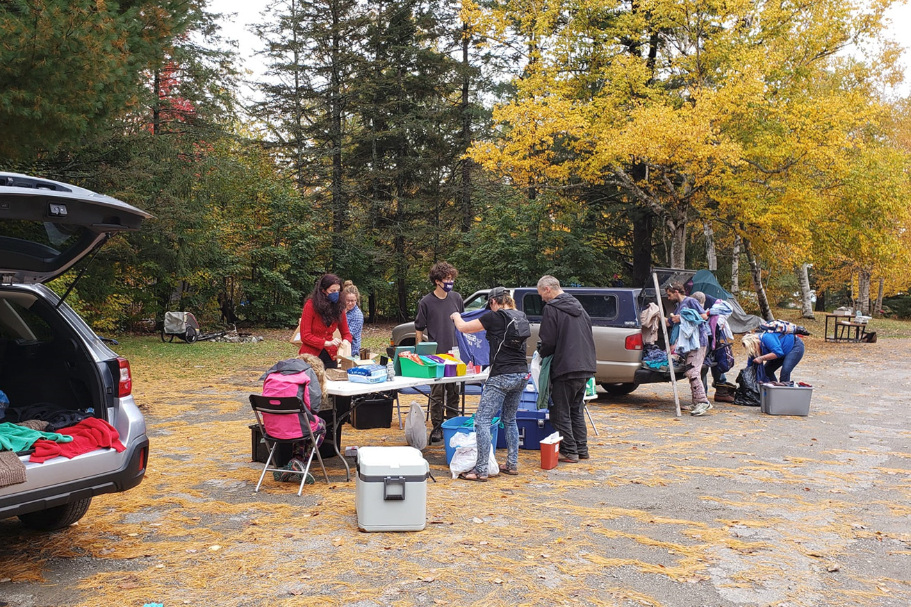 A photo of a Needlepoint Sanctuary crew helping homeless people in a park.