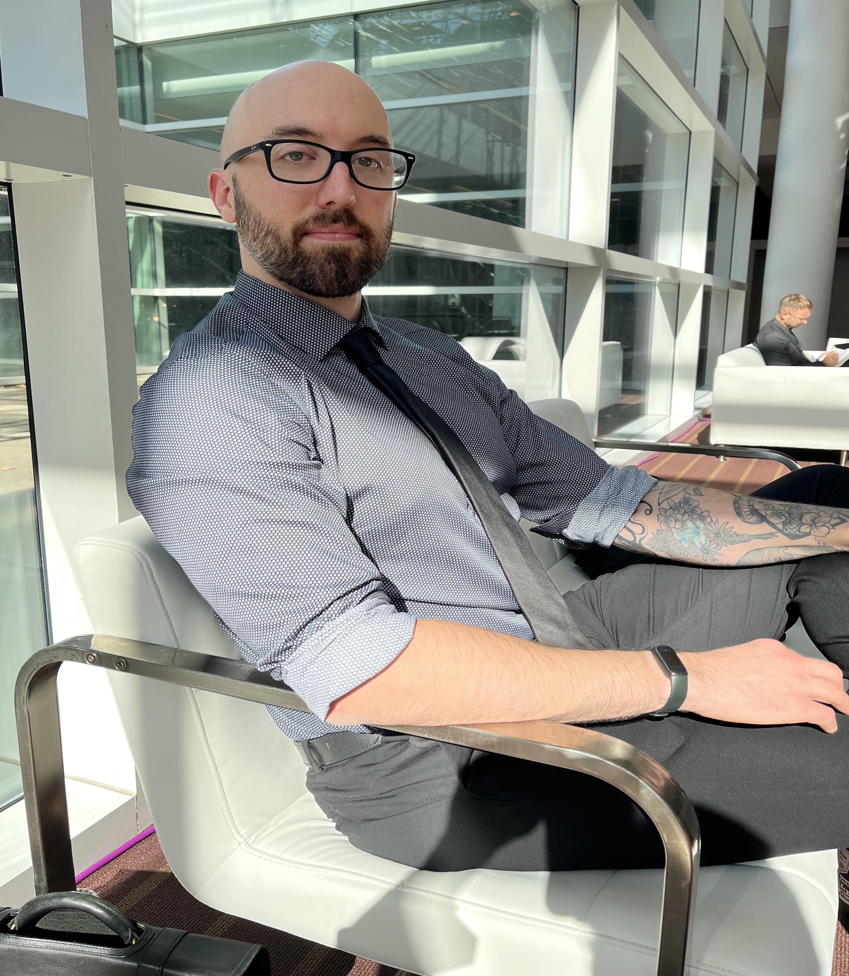 A photo of a man sitting indoors.